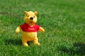 Joyful childhood plush toy scene outdoors, vivid image of playful plush bear on grass under sunlight Royalty Free Stock Photo