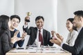 Winning business team with a man executive holding a gold trophy Royalty Free Stock Photo