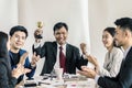 Winning business team with a man executive holding a gold trophy Royalty Free Stock Photo