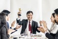 Winning business team with a man executive holding a gold trophy . Royalty Free Stock Photo