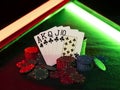 Winning combination in poker standing leaning on multicolored chips piles on green cover of playing table, under green