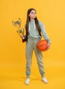 winning the game. sport champion. teen girl with basketball ball and champion cup. happy basketball champion. sport