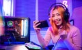 Happy Gamer playing video game online with smartphone she raises hands to wins
