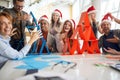 Winning team in game of making card towers showing off. people with santa hats in office. christmastime Royalty Free Stock Photo