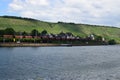 Winningen, Germany - 06 25 2020: waterfront of Winningen with a freight train passing below the steep vineyards