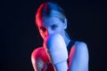 Winsome Active Female Boxer Posing in White Gloves And Making Hit Against Dark Background With Colorul Lights