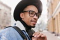 Winsome african male model posing with pensive face expression on city background. Close-up photo of black young man Royalty Free Stock Photo