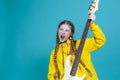 Winsome Caucasian Female Guitar Player With Yellow Bass Guitar Posing In Fashionable Yellow Hoody Jacket While Singing Over Trendy