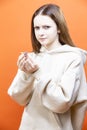 Winsome Caucasian Young Woman Cleaning Ear with Cotton Swab on Orange Background