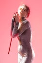 Winsome Expressive Singing Caucasian Girl In Gray Reflective Dress Posing With Microphone On Pink Background