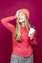 Winsome Positive Young Happy Emotional Cheerful Caucasian Girl Laughing In Knitted Autumn Hat and Sweater With Cup of Coffee on Royalty Free Stock Photo