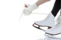 Winter Activity. Closeup of Teenager Girl Hands Lacing Up Ice Skates Against White