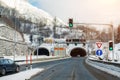 Winter alpine road landscape with tunnel, forest, mountains and blue sky on background at bright cold sunny day. Car Royalty Free Stock Photo