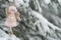 Winter angel on a snowy tree. Snow fairy.Christmas and New Years time. Christmas symbol.Christmas tree toy.