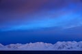 Winter Arctic. White snowy mountain, blue glacier Svalbard, Norway. Ice in ocean. Iceberg twilight in North pole. Pink clouds with