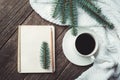 Winter and autumn composition. Top view of vintage notebook with fir tree and pencil, decorated with cup of coffee