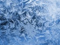 Winter background. Blue with white tinted wallpaper. Drawing of crystals of ice and frost on the window glass. Frozen surface. Royalty Free Stock Photo