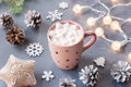 Winter background with hot drink with marshmallows, Christmas lights, fir tree and decorations. Royalty Free Stock Photo