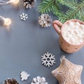 Winter background with hot drink with marshmallows, Christmas lights, fir tree and decorations. Royalty Free Stock Photo