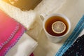 Winter background picture pile of warm woolen clothes on table, a cup of hot tea.