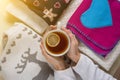 Winter background picture pile of warm woolen clothes on table, a cup of hot tea.