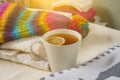 Winter background picture pile of warm woolen clothes on table, a cup of hot tea.