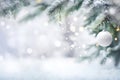 Winter background. Pine tree branches with Christmas ornament and falling snow Royalty Free Stock Photo