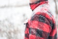 Winter background with snow covered man in red jacket