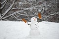 Winter background with snowflakes and snowman. Happy snowman with gift boxes standing in winter Christmas landscape Royalty Free Stock Photo