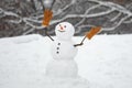 Winter background with snowflakes and snowman. Happy snowman with gift boxes standing in winter Christmas landscape Royalty Free Stock Photo