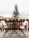 Winter balcony with coffee table, cozy chairs covered with white fur and splendid snow-covered mountains view. Winter Royalty Free Stock Photo