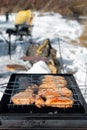 Winter barbecue outdoors, grill steak meat over hot coals in BBQ at campsite cookout, close up view, camping lifestyle Royalty Free Stock Photo