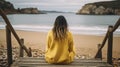 A Winter Beach Moment Captured. A young woman wearing a warm yellow sweater. Generative AI Royalty Free Stock Photo