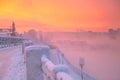 Winter beautiful sunset and mist above the water of river. Frosty weather, trees are covered with fluffy hoarfrost - urban winter