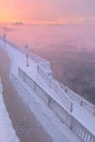 Winter beautiful sunset and mist above the water of river. Frosty weather, trees are covered with fluffy hoarfrost - urban winter