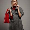 Winter beautiful Woman with Handbag. Beauty Fashion Girl in topcoat