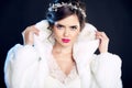 Winter beauty Elegant woman in white fur coat. Fashion model portrait isolated on dark background. Jewelry. Wedding hairstyle. Ma