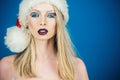 Winter beauty woman. Christmas girl makeup. Sexy female model with festive makeup in Santa Claus hat. Christmas holidays Royalty Free Stock Photo