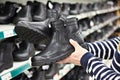 Winter boots in hands of man customers at store