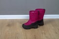 Winter boots snowboots dark pink with black soles on the floor in the room Royalty Free Stock Photo