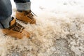 Winter Boots in Wet Dirty Snow, Warm Winter Shoes, Waterproof Surface, Hiking Footwear, Brown Winter Boots Royalty Free Stock Photo