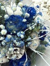 Winter bouquet of white and blue flowers. Flowers bouquet including Blue roses covered with snow, cones, fir branches, cotton ball