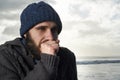 Winter, breathing and ocean with man, thinking and cold weather with waves and freezing. Person, beach or guy with wool Royalty Free Stock Photo