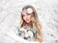 Cute bride in the winter snow forest outdoors with beautiful flowers on her head and a bouquet. Wedding makeup Royalty Free Stock Photo