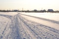 Winter bright landscape. Snowmobile tracks in the snow in the middle of snowdrifts in a snow-covered field against the backdrop of Royalty Free Stock Photo