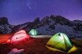 Winter camp, night, shining green tent in the snow. Night shot, long exposure, sleeping in the snow outside. Alps mountains