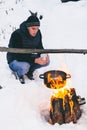 Winter camping, man warm up hands. Boiling water in pot. Wilderness and snow. Witnter time Royalty Free Stock Photo