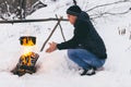 Winter camping, man warm up hands. Boiling water in pot. Wilderness and snow. Witnter time Royalty Free Stock Photo