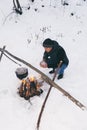 Winter camping, man warm up hands. Boiling water in pot. Wilderness and snow. Witnter time Royalty Free Stock Photo