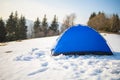 Winter Camping On Snow In The Forest. Blue Tent On Hill.